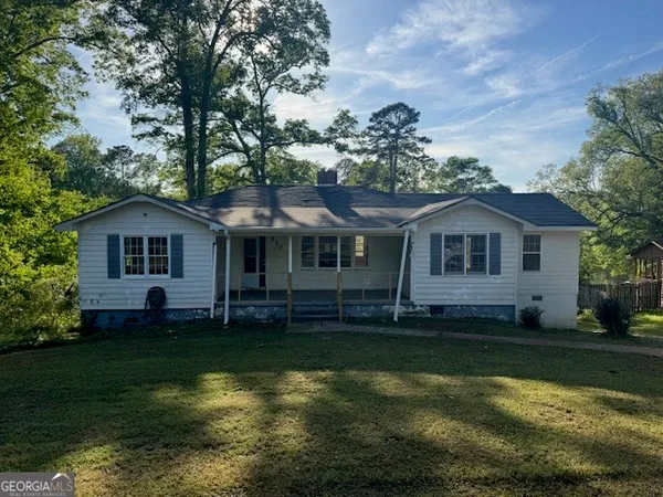 a front view of a house with a garden and yard