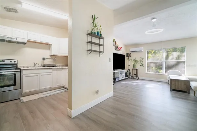 a view of a kitchen with furniture wooden floor and electronic appliances