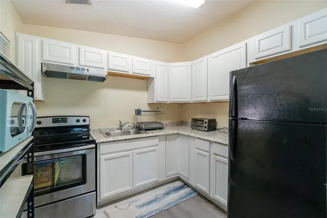 a kitchen with stainless steel appliances a refrigerator sink and cabinets