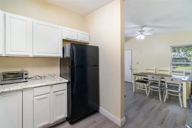 a kitchen with a refrigerator and white cabinets