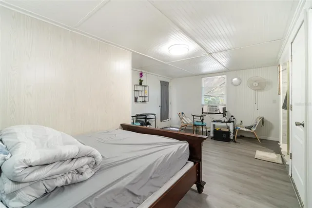 a bedroom with a bed and a wooden floor