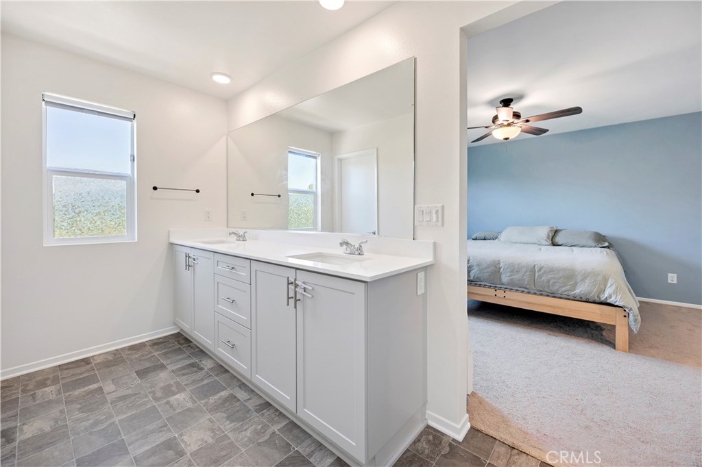 34758 Criollo Way Fallbrook, CA 92028 - Photo 16 of 25 a en suite bathroom with a double vanity sink a mirror and a bathtub