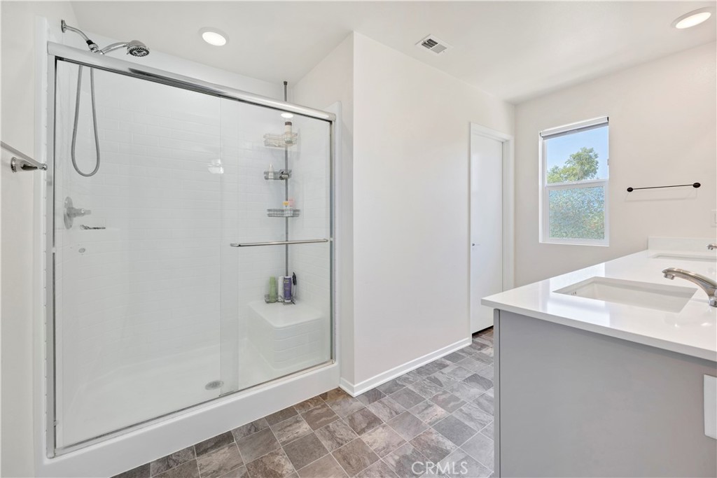 34758 Criollo Way Fallbrook, CA 92028 - Photo 17 of 25 a bathroom with a shower sink and mirror