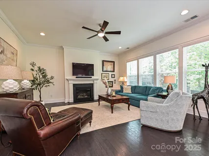 a living room with furniture fireplace and a large window