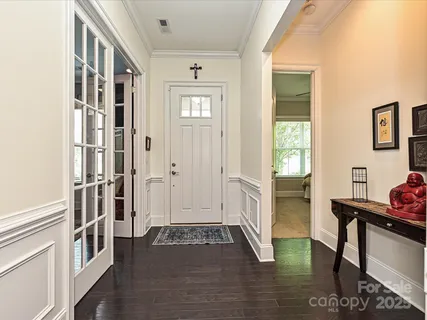 a view of a hallway with wooden floor and dining room