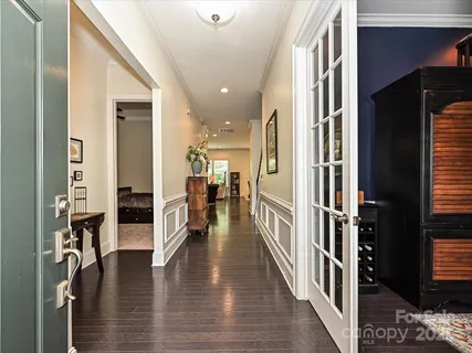 a view of a hallway with wooden floor windows and a livingroom