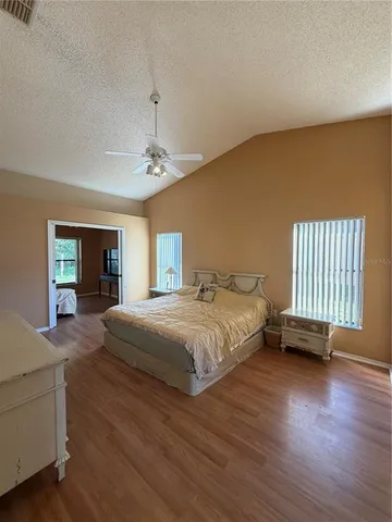 a spacious bedroom with a bed and a dresser next to a window