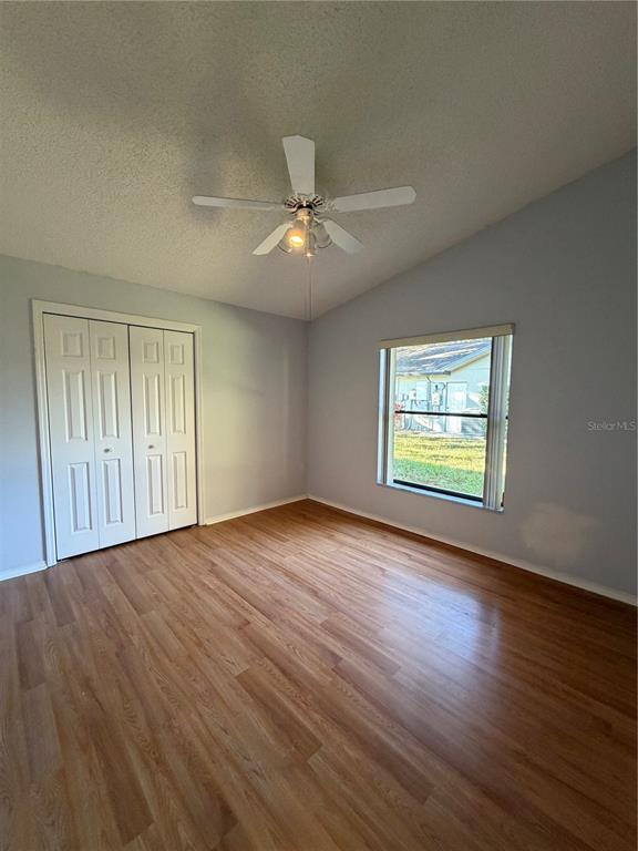 1716 Percheron Drive Trinity, FL 34655 - Photo 22 of 29 an empty room with wooden floor chandelier fan and windows