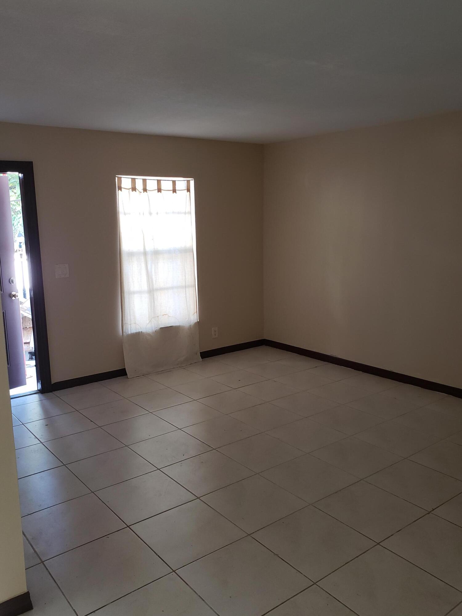 4951 Wedgewood Way, Unit 3 West Palm Beach, FL 33417 - Photo 3 of 4 an empty room with windows