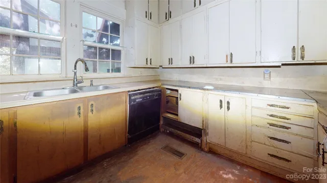a kitchen with stainless steel appliances granite countertop a sink and dishwasher with white cabinets