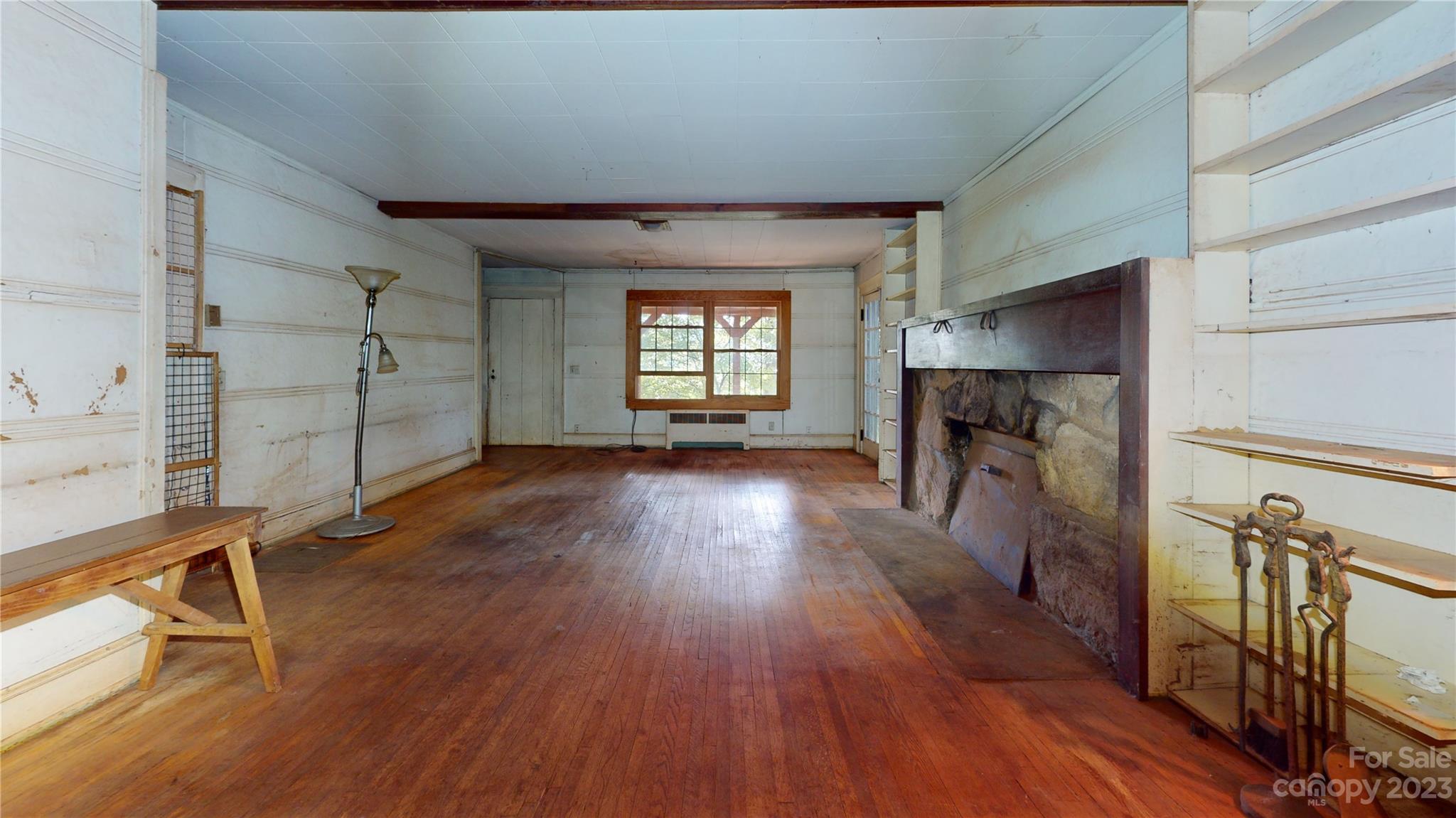 324 Buzzard's Roost Road Cullowhee, NC 28723 - Photo 10 of 18 a hallway with wooden floor fireplace and windows