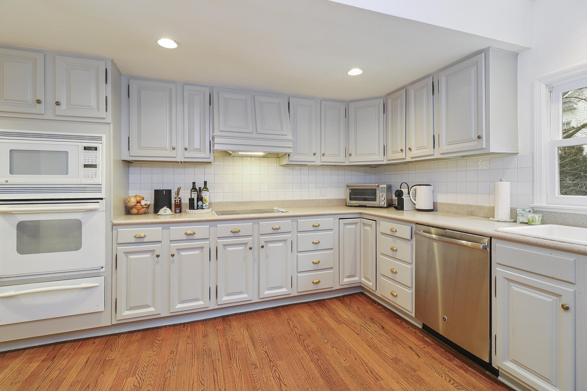 22 Birch Road Darien, CT 06820 - Photo 11 of 40 a kitchen with granite countertop white cabinets and white appliances