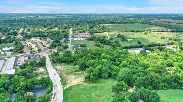 an aerial view of residential houses with outdoor space and trees