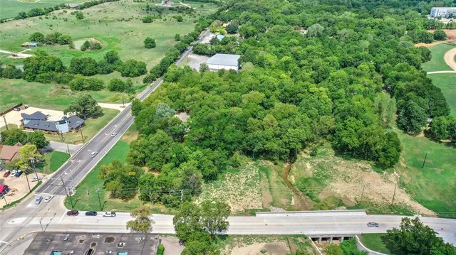 an aerial view of residential houses with outdoor space and trees
