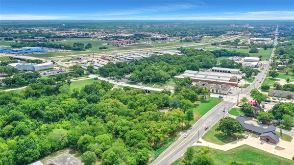 an aerial view of residential houses with outdoor space and trees