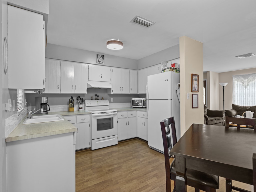 7304 Arthurs Road Fort Pierce, FL 34951 - Photo 11 of 29 a kitchen with white cabinets and white appliances
