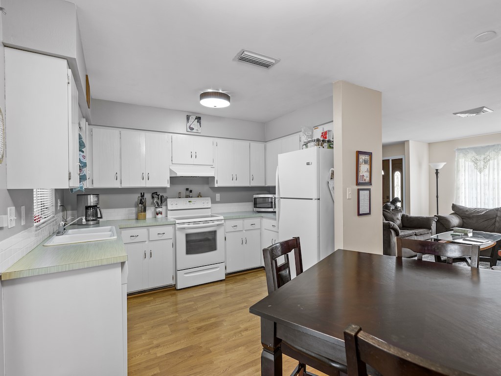 7304 Arthurs Road Fort Pierce, FL 34951 - Photo 15 of 29 a kitchen with a table chairs refrigerator and cabinets