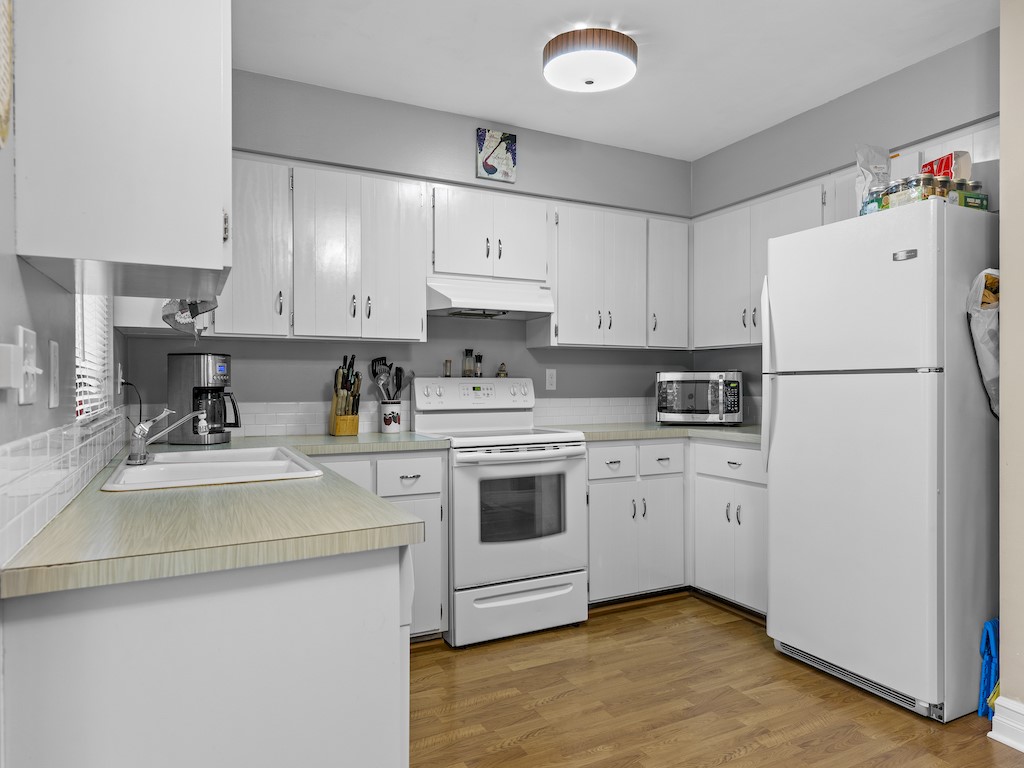 7304 Arthurs Road Fort Pierce, FL 34951 - Photo 16 of 29 a kitchen with a white cabinets and white appliances
