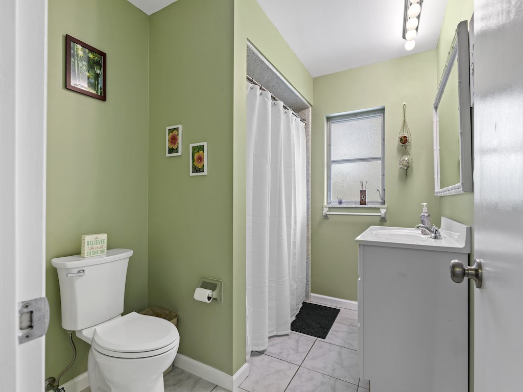 7304 Arthurs Road Fort Pierce, FL 34951 - Photo 20 of 29 a bathroom with a toilet sink and mirror