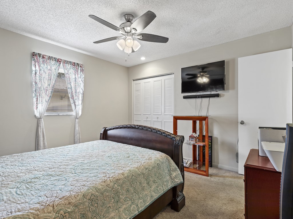 7304 Arthurs Road Fort Pierce, FL 34951 - Photo 22 of 29 a bedroom with a bed a flat screen tv and dresser