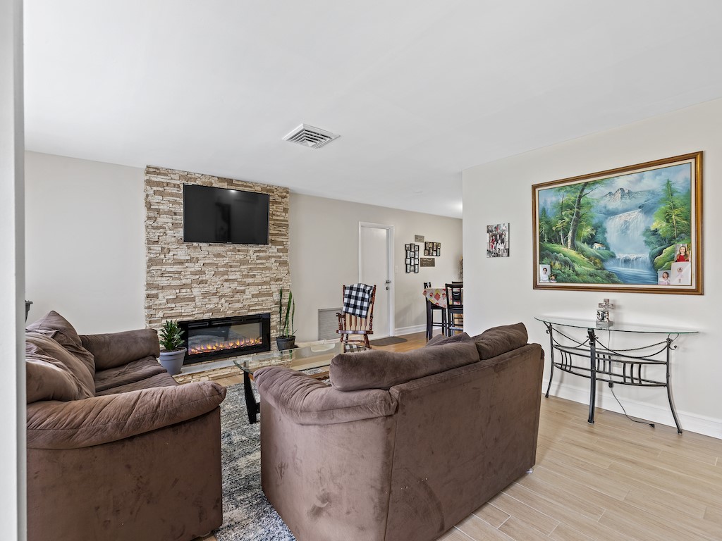 7304 Arthurs Road Fort Pierce, FL 34951 - Photo 3 of 29 a living room with furniture a fireplace and a flat screen tv