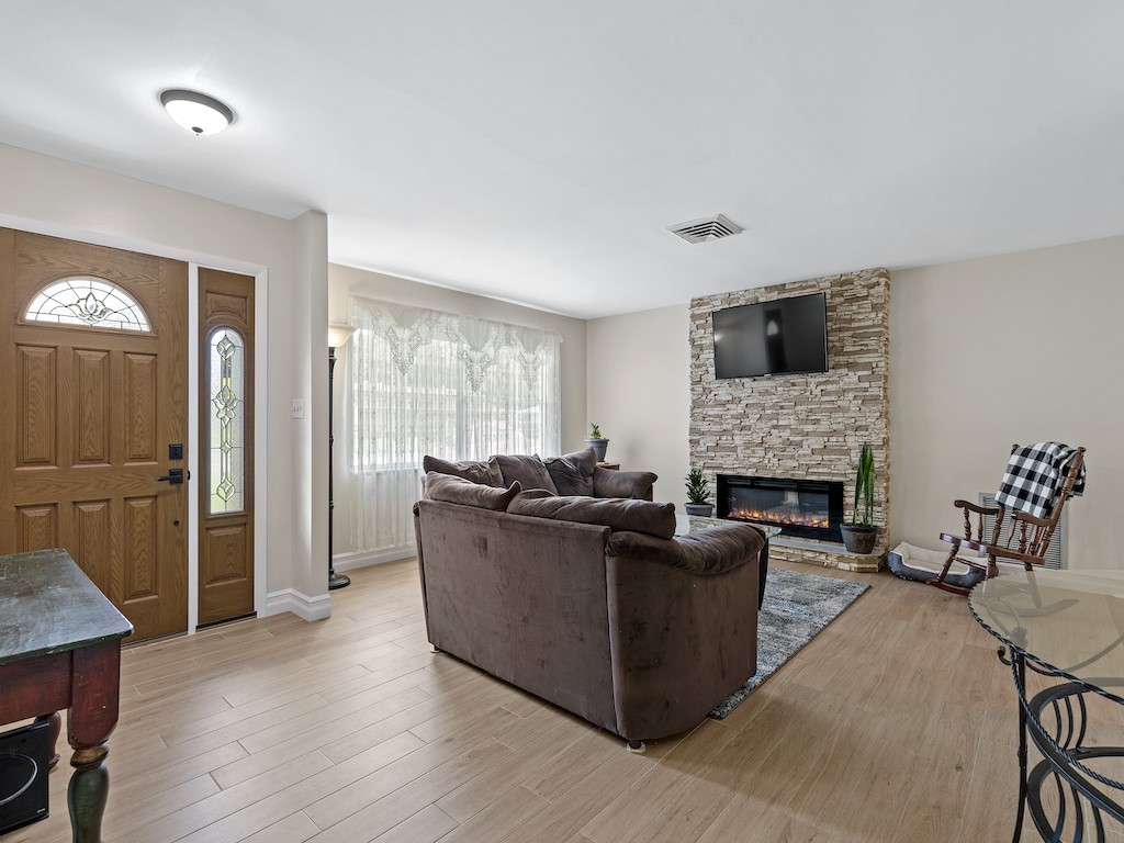 7304 Arthurs Road Fort Pierce, FL 34951 - Photo 6 of 29 a living room with furniture a flat screen tv and a fireplace