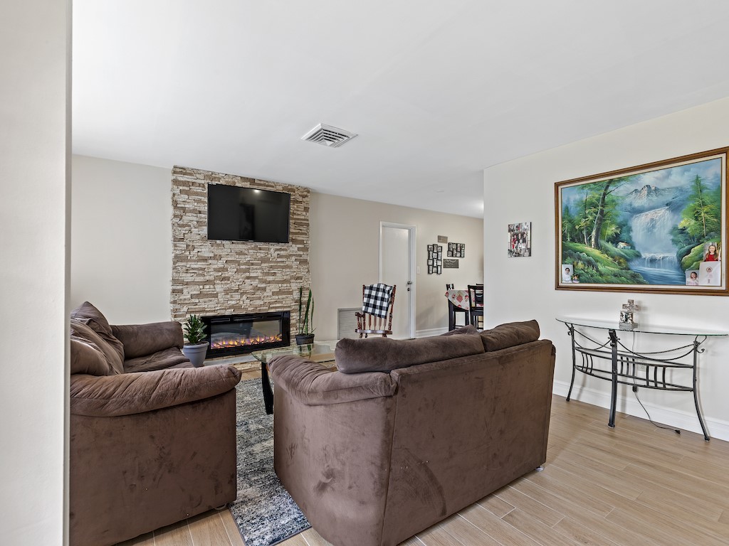 7304 Arthurs Road Fort Pierce, FL 34951 - Photo 7 of 29 a living room with furniture a fireplace and a flat screen tv