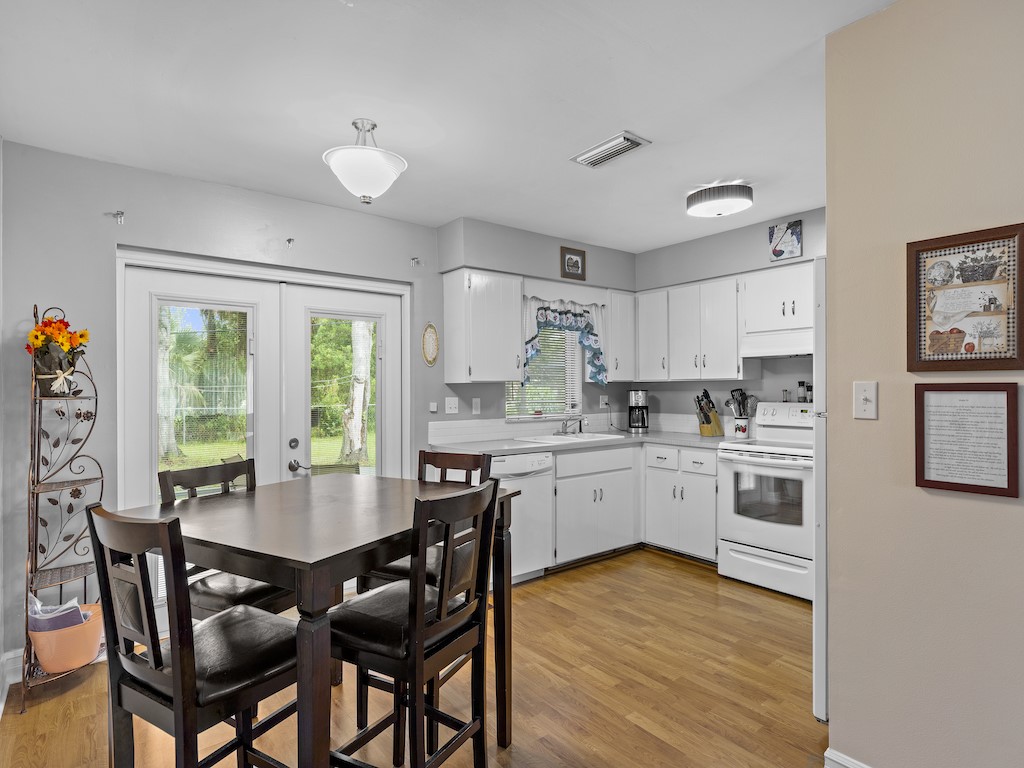 7304 Arthurs Road Fort Pierce, FL 34951 - Photo 9 of 29 a kitchen with stainless steel appliances granite countertop a stove a refrigerator a kitchen island a table and chairs in it