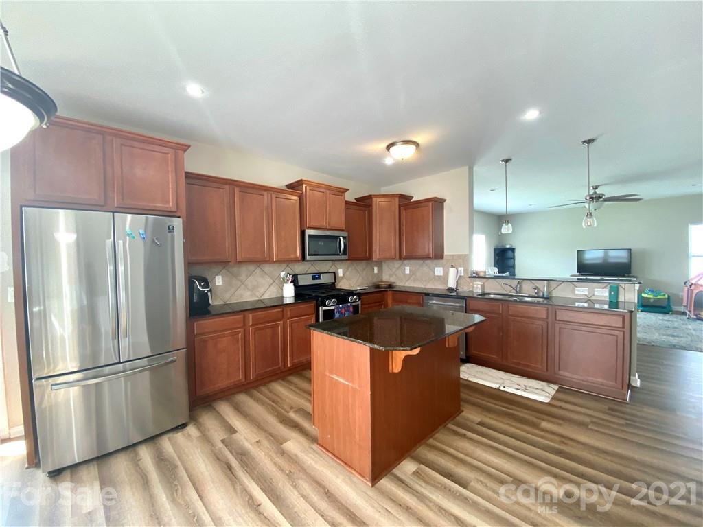 8009 Bryson Road Indian Land, SC 29707 - Photo 11 of 45 a kitchen with stainless steel appliances granite countertop a refrigerator a stove a sink and a microwave