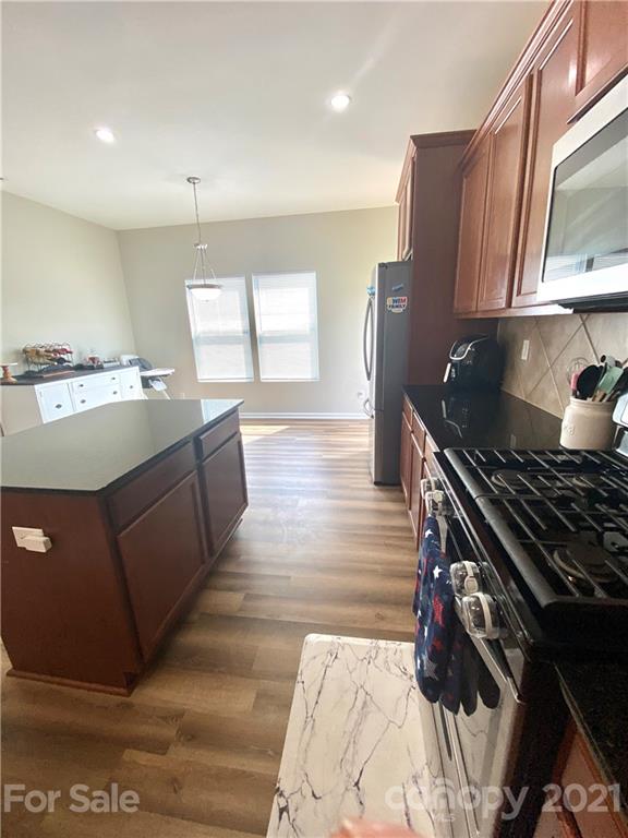 8009 Bryson Road Indian Land, SC 29707 - Photo 14 of 45 a kitchen with stainless steel appliances granite countertop a stove a sink and a microwave