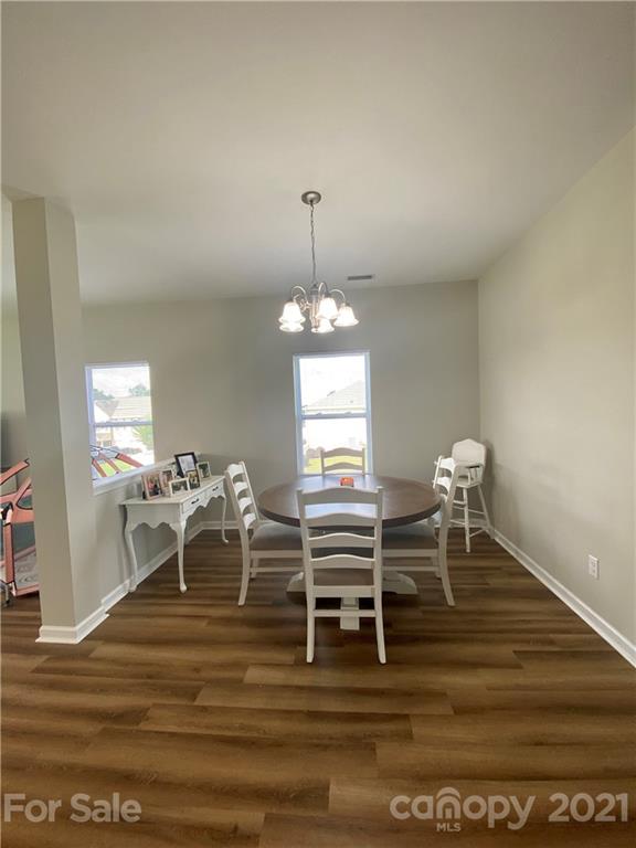 8009 Bryson Road Indian Land, SC 29707 - Photo 19 of 45 a dining room with furniture a chandelier and wooden floor