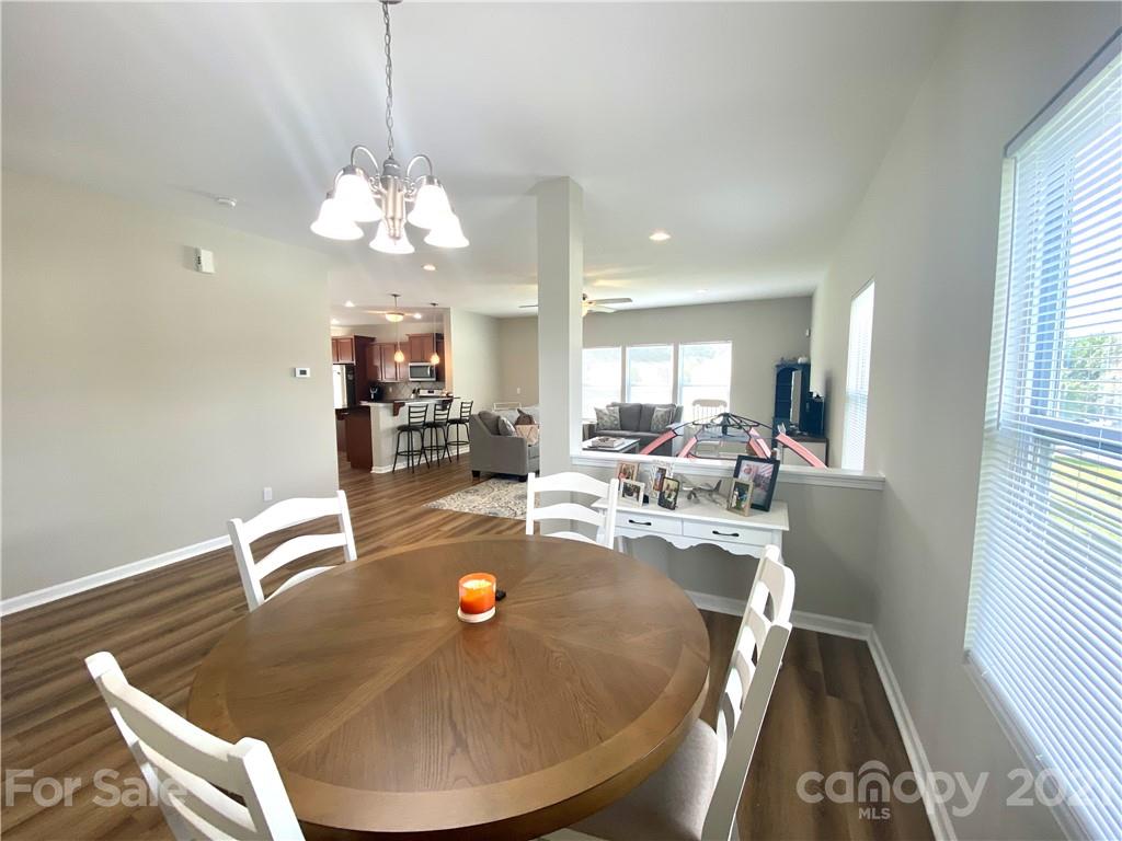 8009 Bryson Road Indian Land, SC 29707 - Photo 20 of 45 a view of a dining room with furniture a chandelier and wooden floor