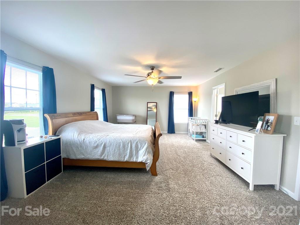 8009 Bryson Road Indian Land, SC 29707 - Photo 25 of 45 a spacious bedroom with a bed and a flat screen tv