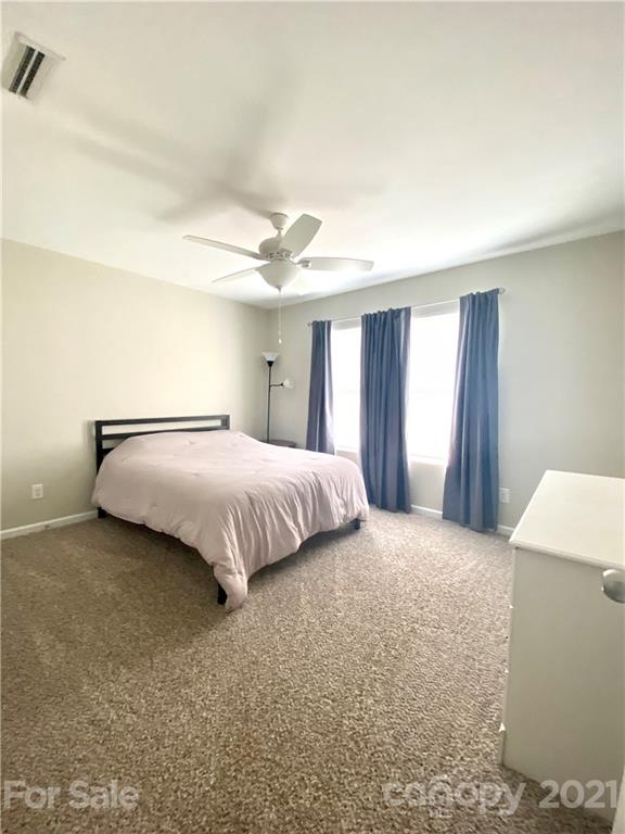 8009 Bryson Road Indian Land, SC 29707 - Photo 43 of 45 a bedroom with a bed and a chandelier