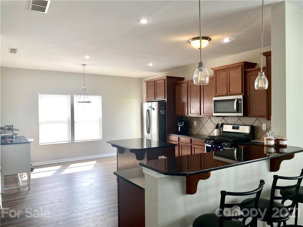 8009 Bryson Road Indian Land, SC 29707 - Photo 7 of 45 a kitchen with stainless steel appliances a dining table and chairs