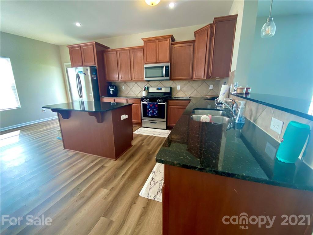 8009 Bryson Road Indian Land, SC 29707 - Photo 9 of 45 a kitchen with stainless steel appliances granite countertop a refrigerator a stove top oven a sink and dishwasher