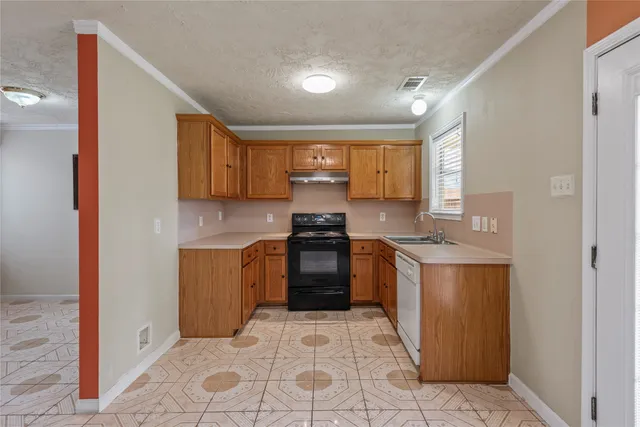 a kitchen with granite countertop a stove top oven sink and cabinets