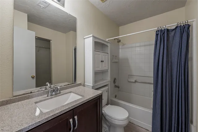 a bathroom with a sink a toilet a mirror and shower