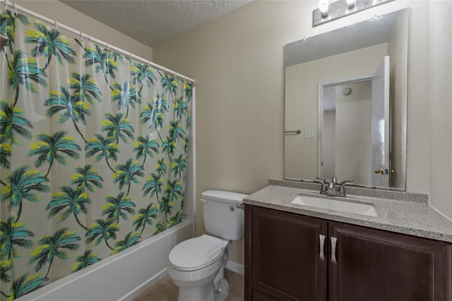 a bathroom with a granite countertop sink a toilet and a mirror