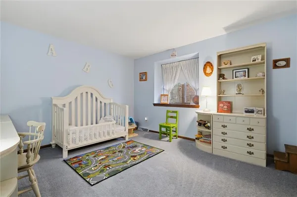 a living room with furniture and a baby crib