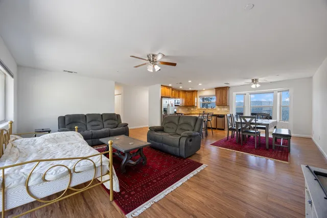 a living room with furniture kitchen view and a wooden floor