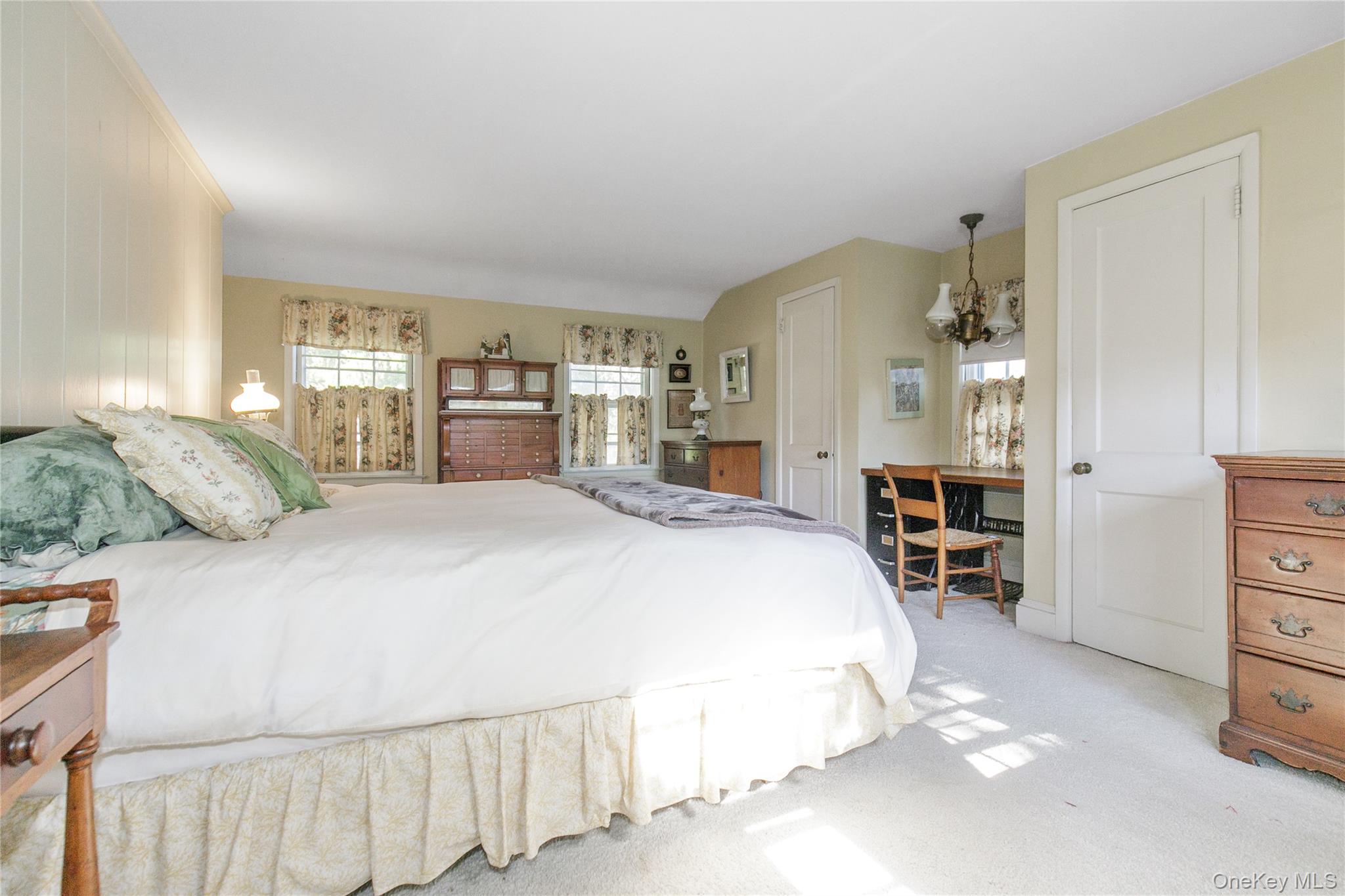 26 Vista Hill Road Great Neck, NY 11021 - Photo 19 of 35 a spacious bedroom with a bed a dresser and a window