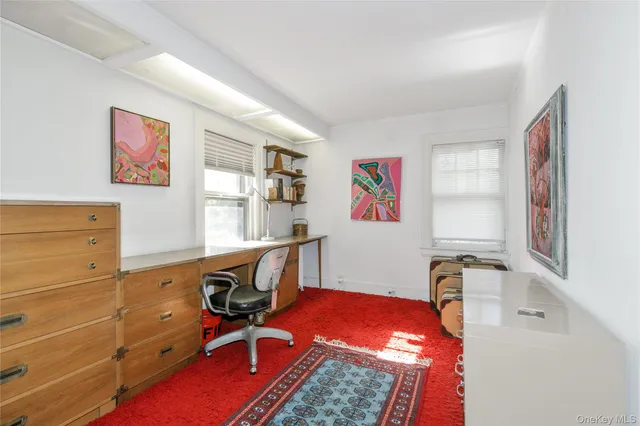 a view of a workspace with furniture and a window
