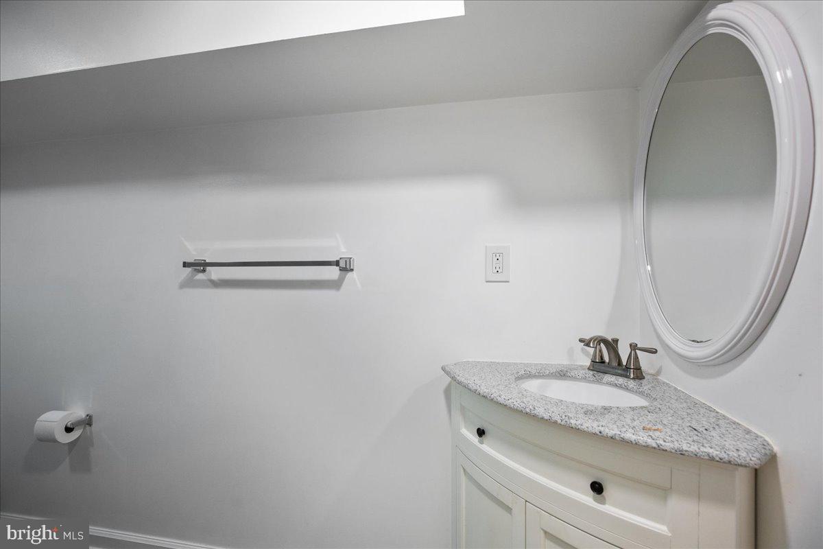 22 Cedarwood Road Catonsville, MD 21228 - Photo 33 of 44 a bathroom with a granite countertop sink a mirror and vanity