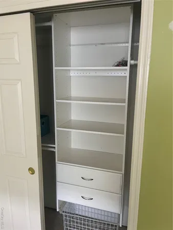 a view of walk in closet with empty racks