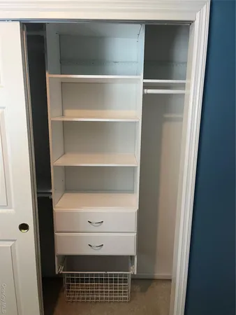 a view of walk in closet with empty racks