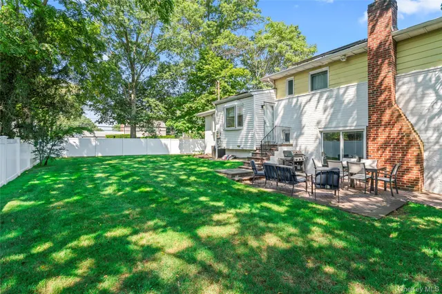 a view of backyard of house with outdoor seating and green space