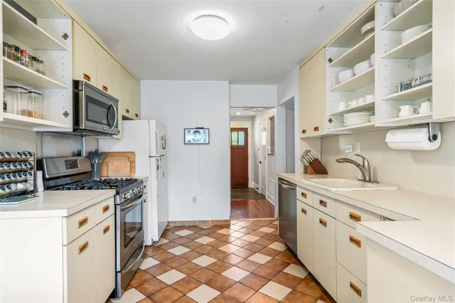 a kitchen with stainless steel appliances a stove a sink and a refrigerator