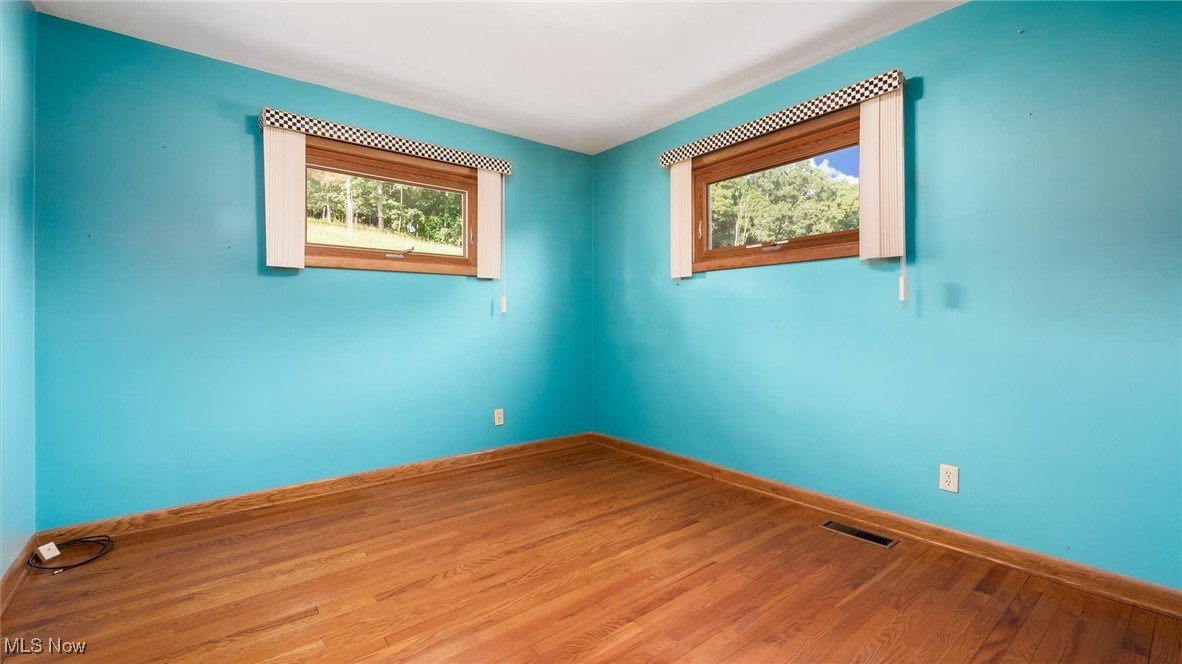 165 Old Rix Mills Road New Concord, OH 43762 - Photo 13 of 34 Spare room with visible vents, baseboards, and wood finished floors