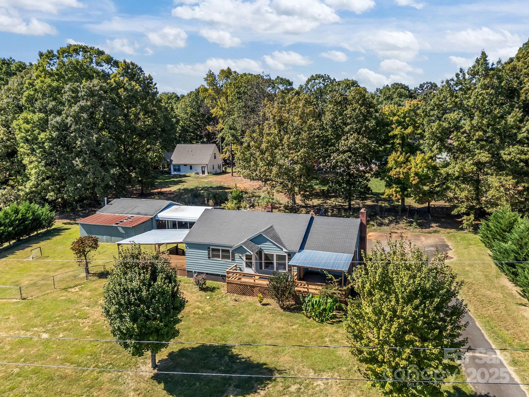 104 Pine Road Mount Holly, NC 28120 - Photo 2 of 46 an aerial view of a house with swimming pool and red chairs